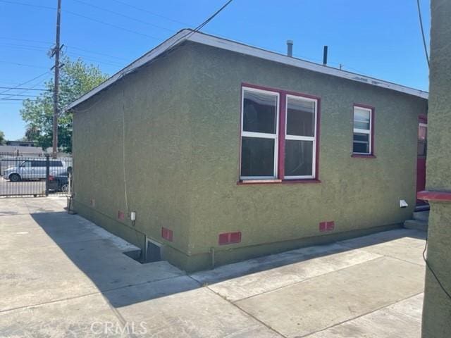 10807 Compton Ave, Los Angeles, CA 90059 - view of side of home featuring crawl space, stucco siding, and a patio