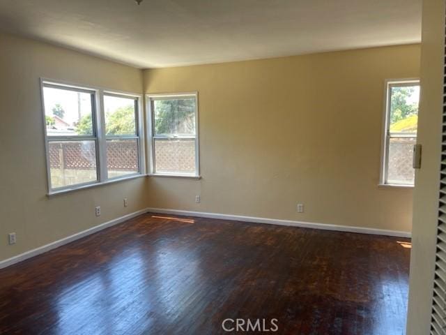 empty room with baseboards and wood finished floors