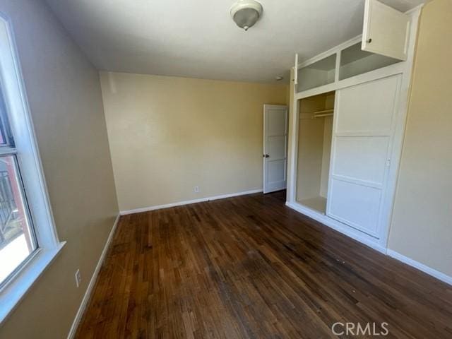 10807 Compton Ave, Los Angeles, CA 90059 - unfurnished bedroom with dark wood-style floors and a closet
