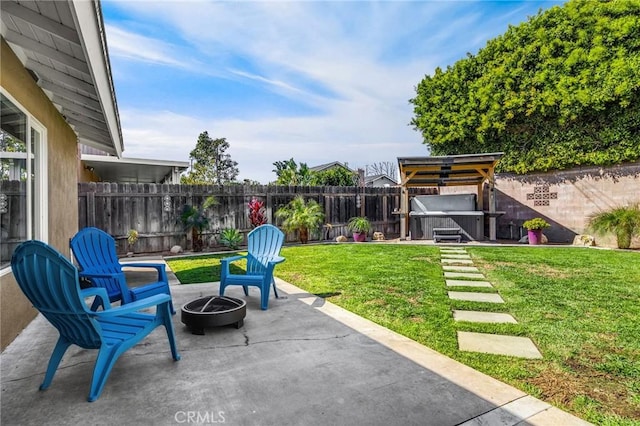 view of patio / terrace featuring a hot tub, a fire pit, and a fenced backyard