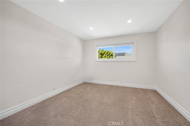 empty room with recessed lighting, light colored carpet, and baseboards