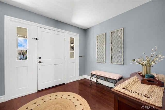 foyer entrance with dark wood finished floors and baseboards