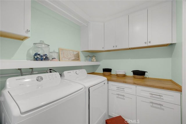 clothes washing area featuring cabinet space and independent washer and dryer