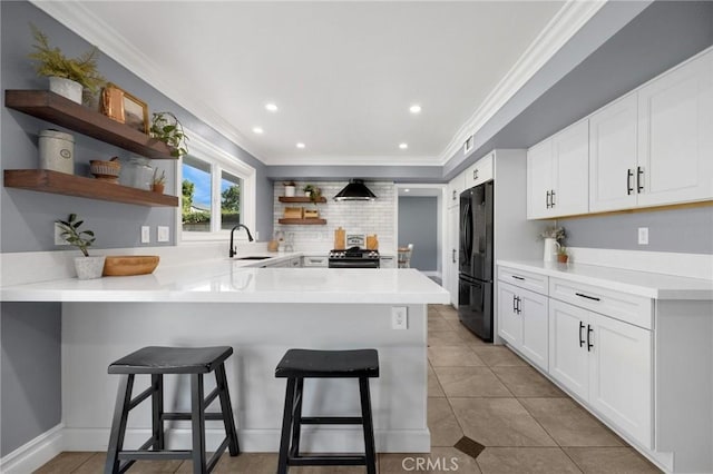 kitchen with black appliances, open shelves, a sink, a peninsula, and crown molding