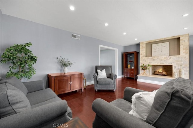 living room with visible vents, dark wood finished floors, recessed lighting, a fireplace, and baseboards