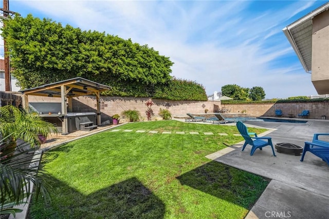 view of yard featuring a fire pit, a fenced backyard, and a hot tub