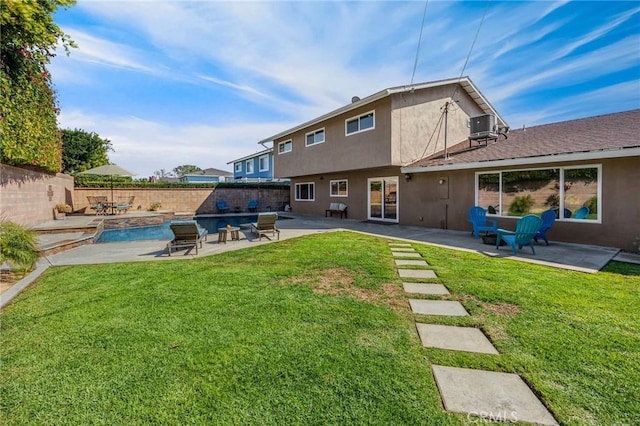 rear view of property with stucco siding, central air condition unit, a yard, and a patio area