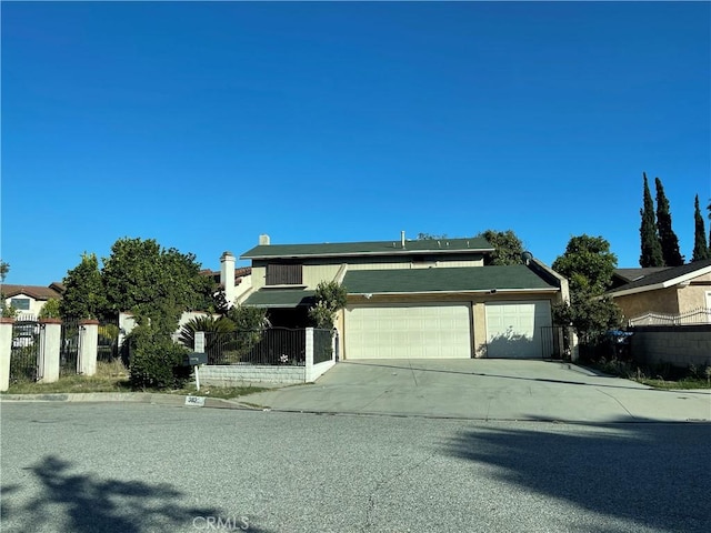 view of front of home featuring a garage, driveway, and fence