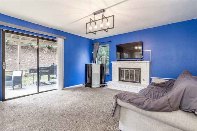 carpeted living area with baseboards, a brick fireplace, and an inviting chandelier