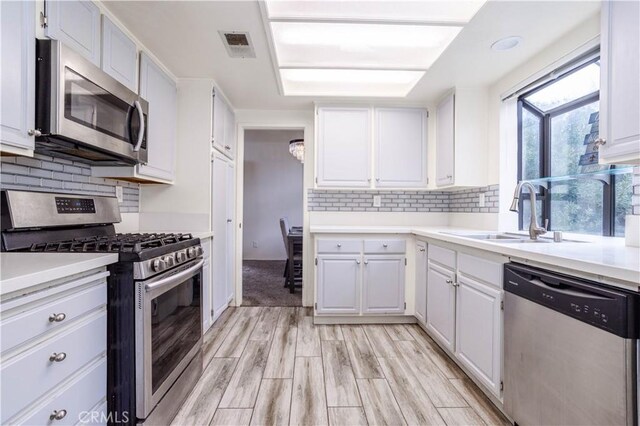 kitchen featuring a sink, stainless steel appliances, and white cabinetry