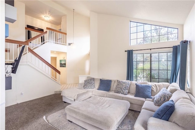 living room featuring stairway, a high ceiling, and carpet flooring