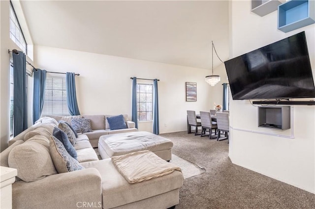 living room featuring a notable chandelier, a high ceiling, and carpet flooring