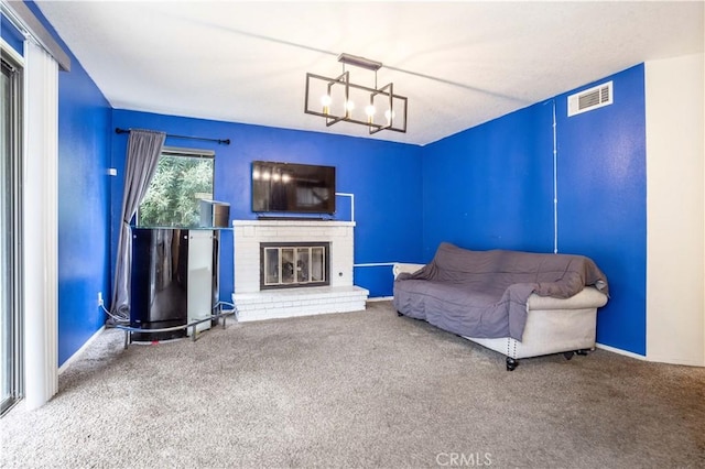 carpeted living area with a chandelier, visible vents, and a fireplace