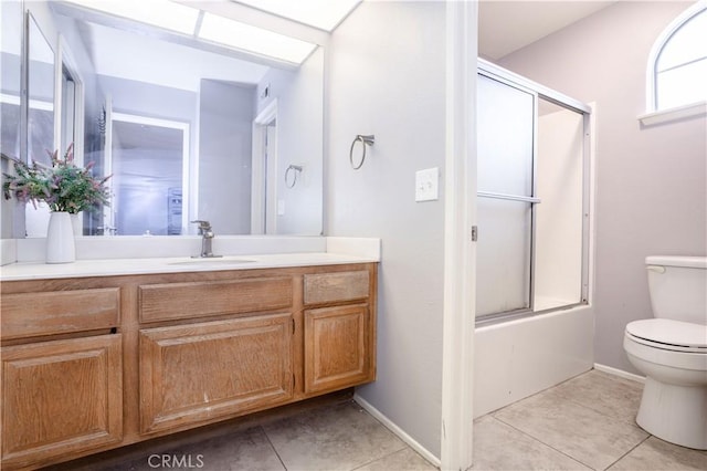 full bath with enclosed tub / shower combo, toilet, vanity, and tile patterned flooring