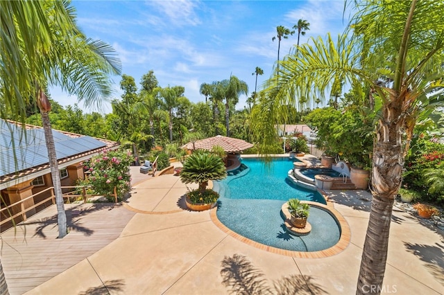 view of pool with a pool with connected hot tub and a patio area