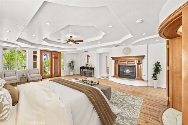 805 E Chase Dr, Corona, CA 92881 - bedroom with access to outside, a raised ceiling, a glass covered fireplace, recessed lighting, and light wood-type flooring