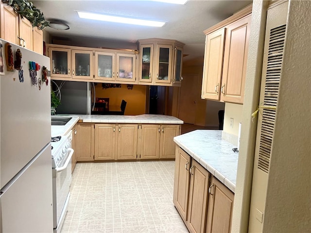 kitchen with glass insert cabinets, white appliances, and light brown cabinets