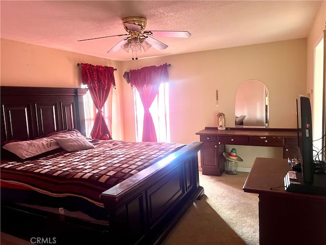 carpeted bedroom with a ceiling fan and a textured ceiling