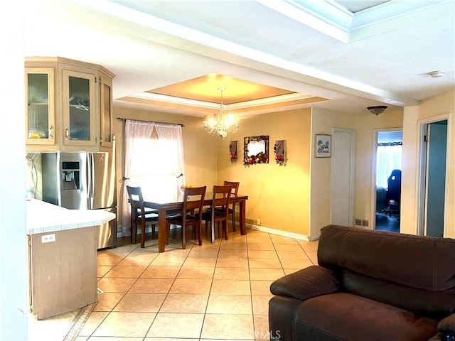 dining space with baseboards, visible vents, an inviting chandelier, a tray ceiling, and light tile patterned flooring