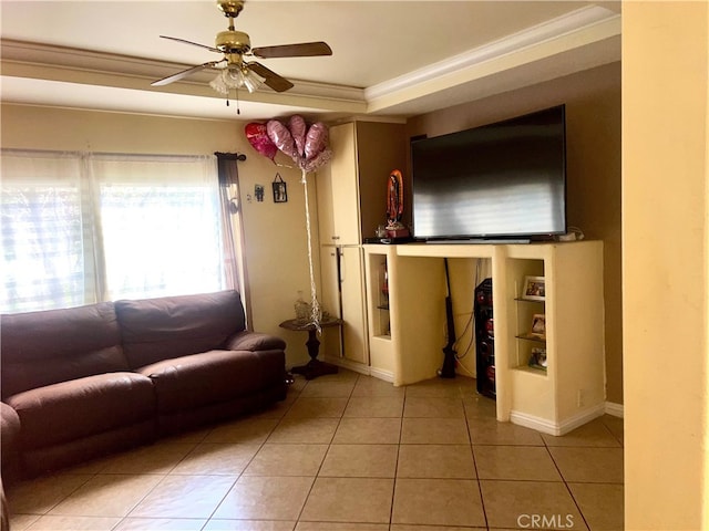 tiled living area featuring a raised ceiling, ornamental molding, baseboards, and ceiling fan