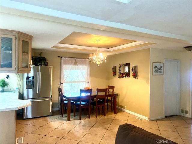 dining room with visible vents, baseboards, a tray ceiling, light tile patterned floors, and an inviting chandelier