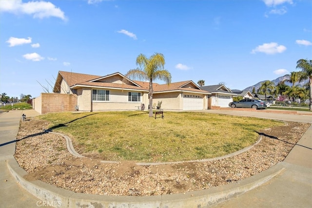 ranch-style house with a front yard, fence, driveway, an attached garage, and stucco siding