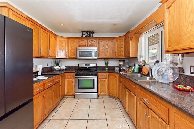 kitchen featuring light tile patterned floors, brown cabinetry, ornamental molding, a sink, and appliances with stainless steel finishes