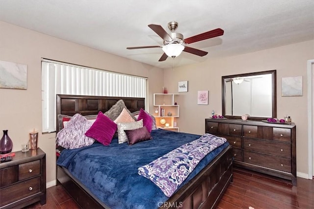 bedroom with baseboards, a ceiling fan, and dark wood-style flooring