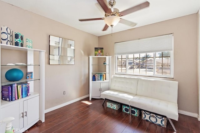 living area with ceiling fan, baseboards, and wood finished floors