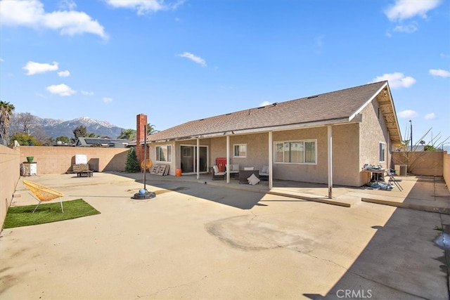 back of house featuring cooling unit, a fenced backyard, stucco siding, a patio area, and a mountain view