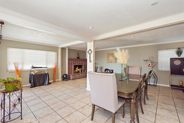 dining area featuring light tile patterned floors, a fireplace, and crown molding