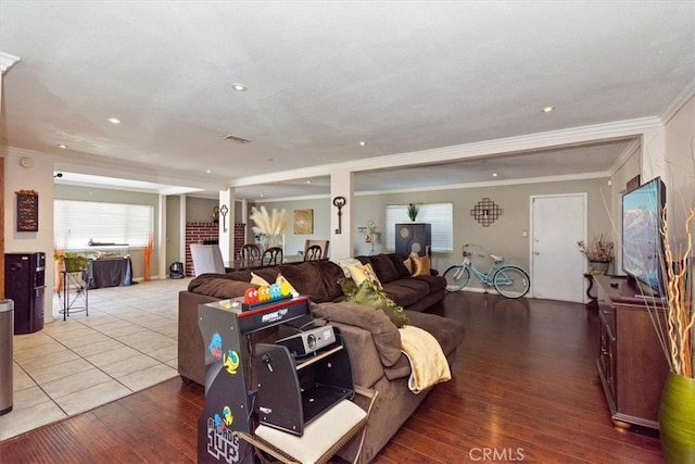 living area featuring recessed lighting, ornamental molding, visible vents, and wood-type flooring