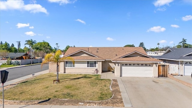 ranch-style house with fence, a front yard, stucco siding, a garage, and driveway