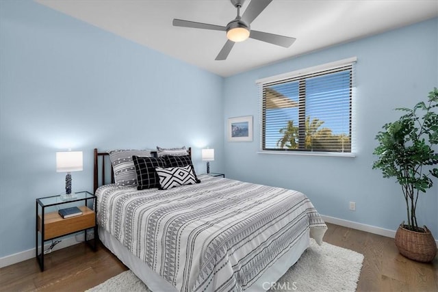 bedroom with baseboards, wood finished floors, and a ceiling fan