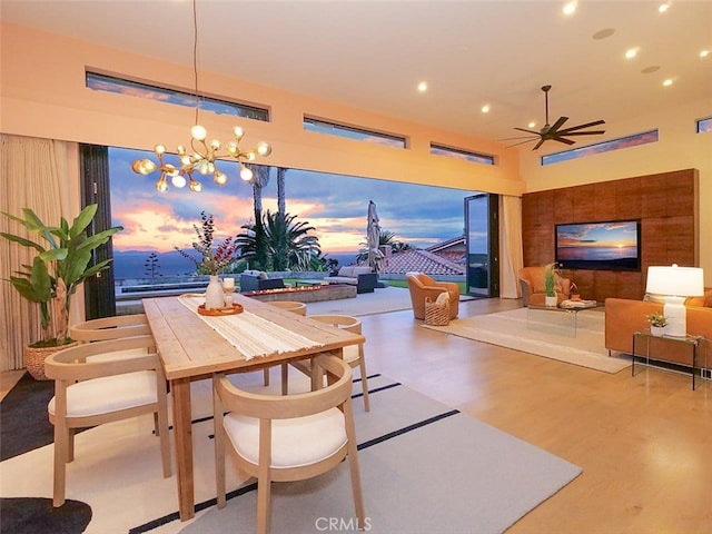 dining room featuring recessed lighting, ceiling fan with notable chandelier, and wood finished floors