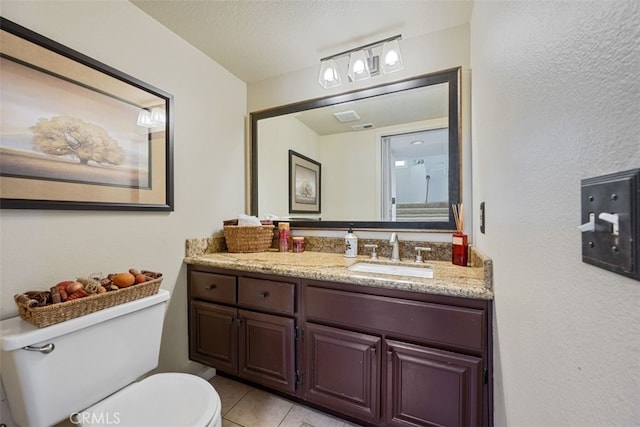 bathroom featuring tile patterned flooring, a textured ceiling, toilet, and vanity