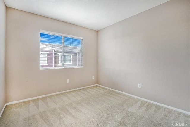 carpeted empty room with baseboards