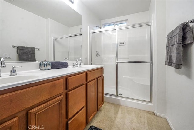 full bath with a shower stall, double vanity, and a sink