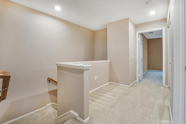 hall with an upstairs landing, baseboards, and carpet floors