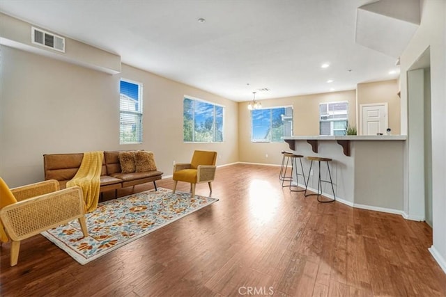 living area featuring wood finished floors, visible vents, baseboards, an inviting chandelier, and recessed lighting