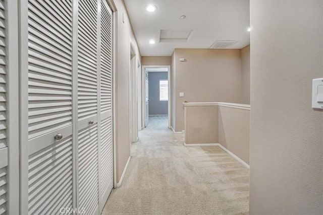 corridor featuring attic access, recessed lighting, light colored carpet, and baseboards