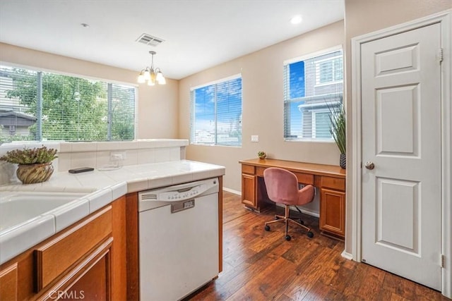 kitchen featuring visible vents, dark wood-style flooring, hanging light fixtures, dishwasher, and brown cabinets