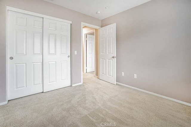 unfurnished bedroom featuring a closet, carpet flooring, and baseboards