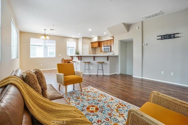 living area with visible vents, baseboards, a chandelier, recessed lighting, and wood finished floors