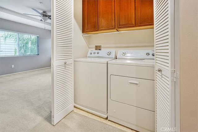 laundry room with cabinet space, light carpet, ceiling fan, and washer and clothes dryer