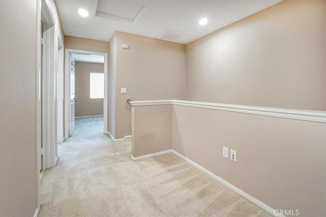 corridor featuring baseboards, light colored carpet, attic access, an upstairs landing, and recessed lighting