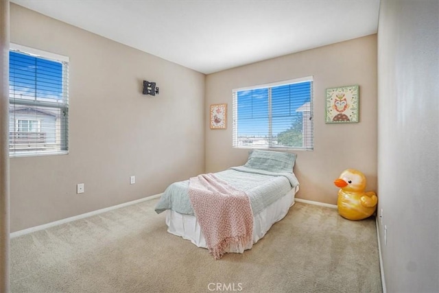 carpeted bedroom with baseboards and multiple windows