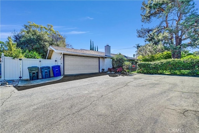 detached garage with a gate and fence