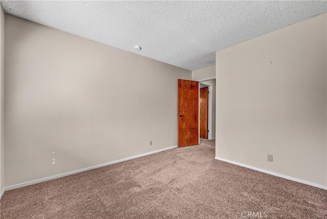 unfurnished room featuring carpet flooring, baseboards, and a textured ceiling