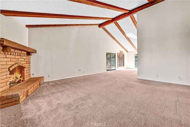 unfurnished living room with beam ceiling, high vaulted ceiling, a brick fireplace, and carpet flooring